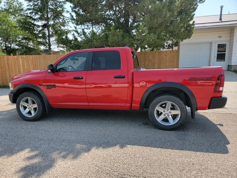 La pickup roja de un cliente con reflejos marcados en los costados