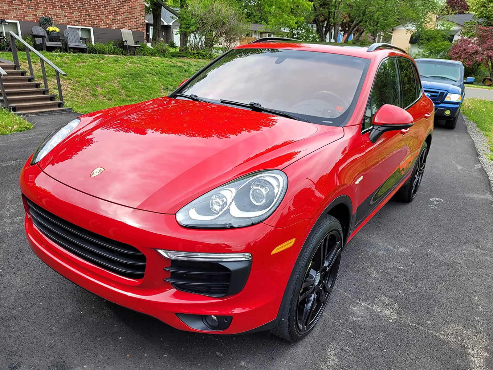 Glossy red Porsche Cayenne with visible Porsche crest